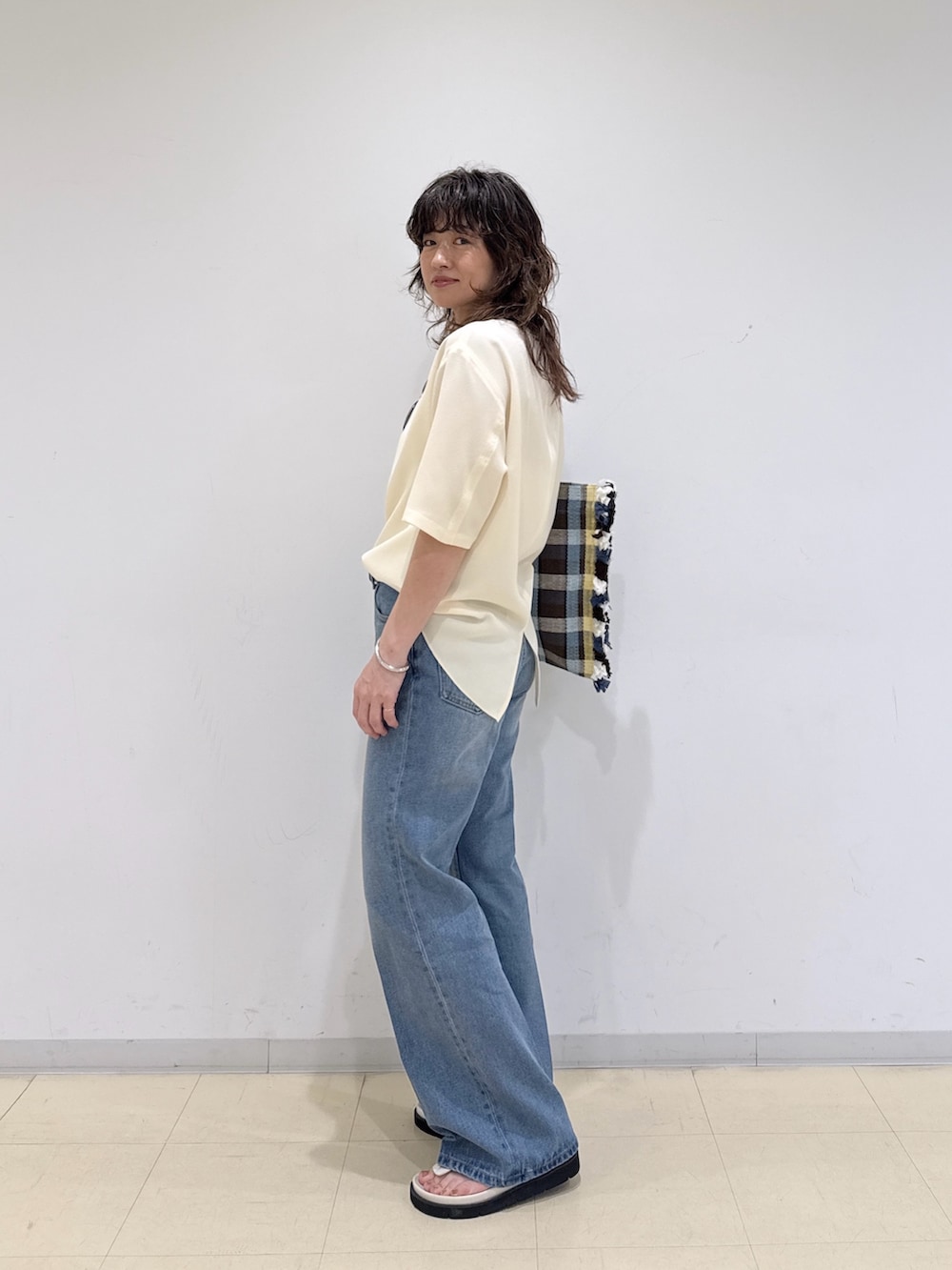 イエロー系のシャツ/ブラウス、ブルー系のデニムパンツ、イエロー系のトートバッグを着用したレディースの春コーディネートの3枚目の写真