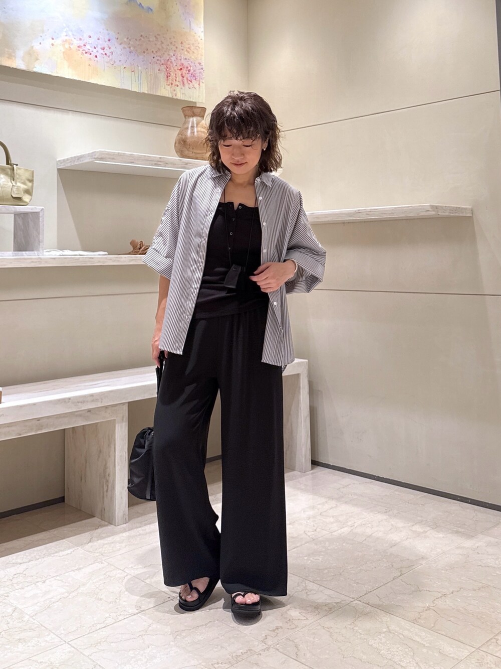ブルー系のシャツ/ブラウス、ブラック系のその他パンツ、ブラック系のトートバッグを着用したレディースの夏コーディネートの4枚目の写真