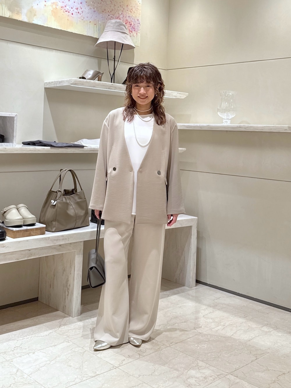 ベージュ系のその他アウター、ベージュ系のその他パンツ、ゴールド系のスリッポンを着用したレディースの春コーディネートの2枚目の写真