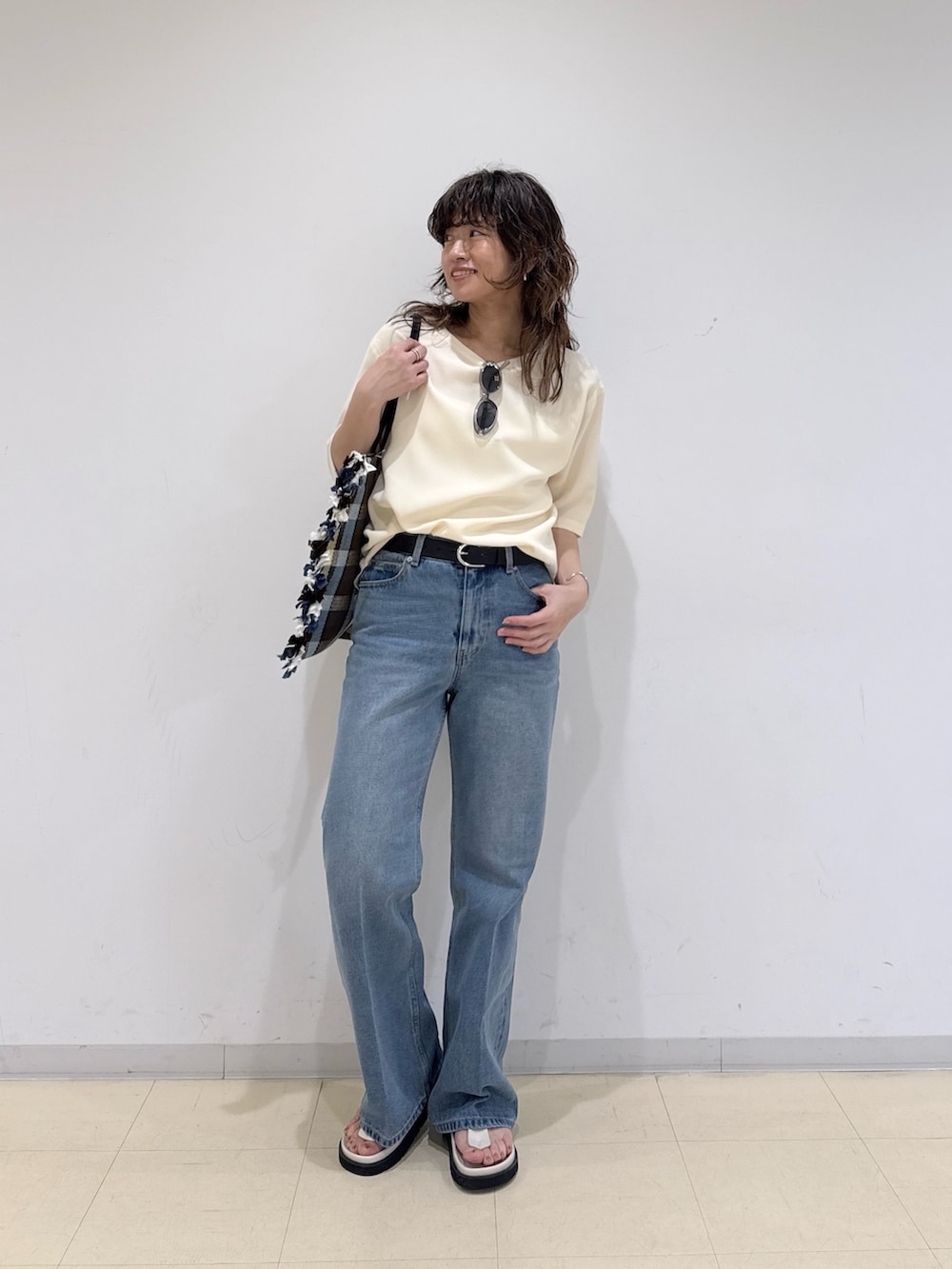 イエロー系のシャツ/ブラウス、ブルー系のデニムパンツ、イエロー系のトートバッグを着用したレディースの春コーディネートの2枚目の写真