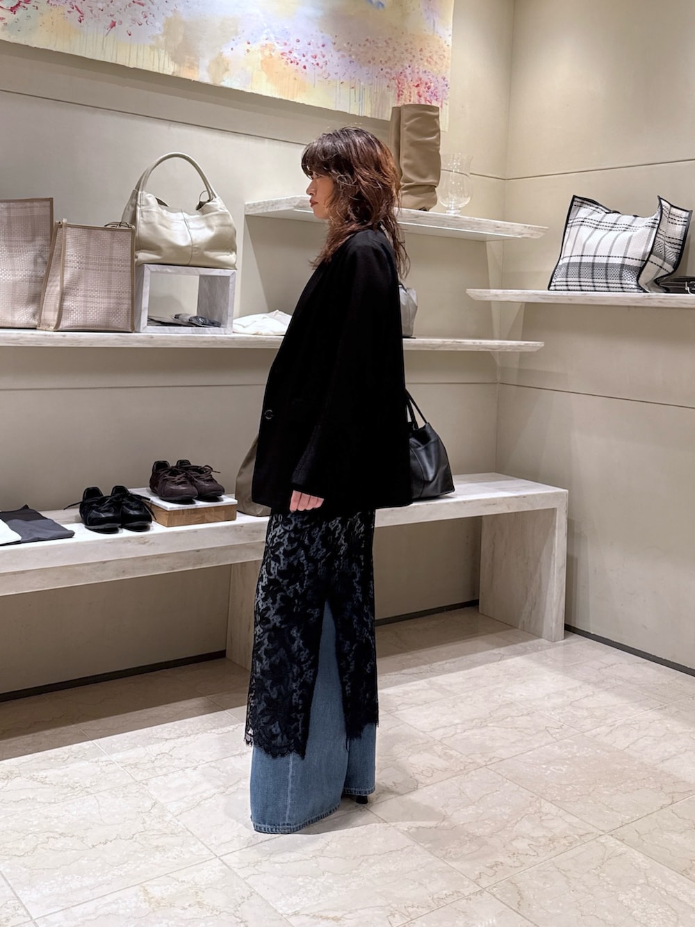 ブラック系のベスト、ブルー系のデニムパンツ、ブラック系のサンダルを着用したレディースの冬コーディネートの2枚目の写真