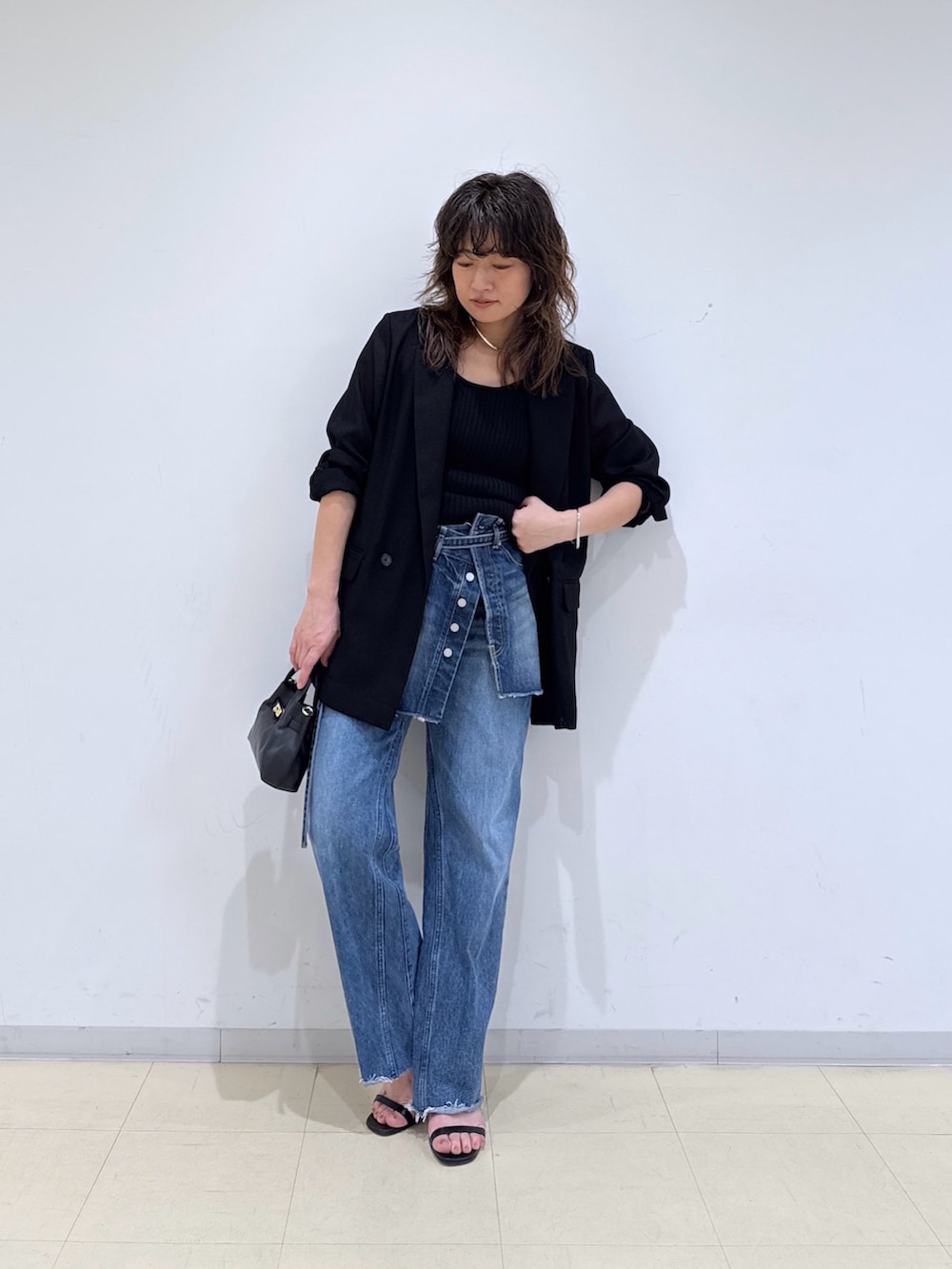 ブルー系のデニムスカート、ブルー系のデニムパンツ、ブラック系のニット/セーターを着用したレディースの春コーディネートの2枚目の写真