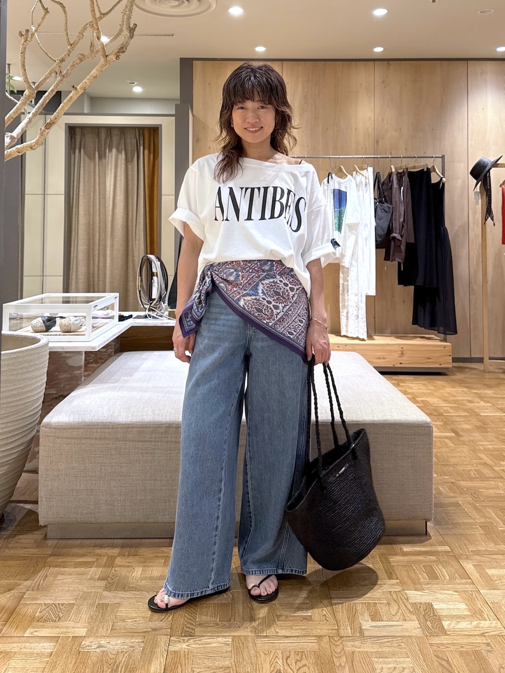 ホワイト系のTシャツ/カットソー、ブルー系のデニムパンツ、ブラック系のトートバッグを着用したレディースの春コーディネートの4枚目の写真