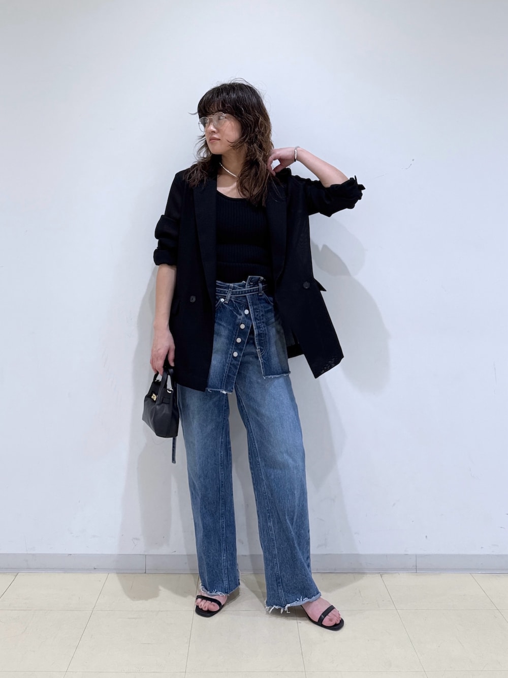 ブルー系のデニムスカート、ブルー系のデニムパンツ、ブラック系のニット/セーターを着用したレディースの春コーディネートの4枚目の写真
