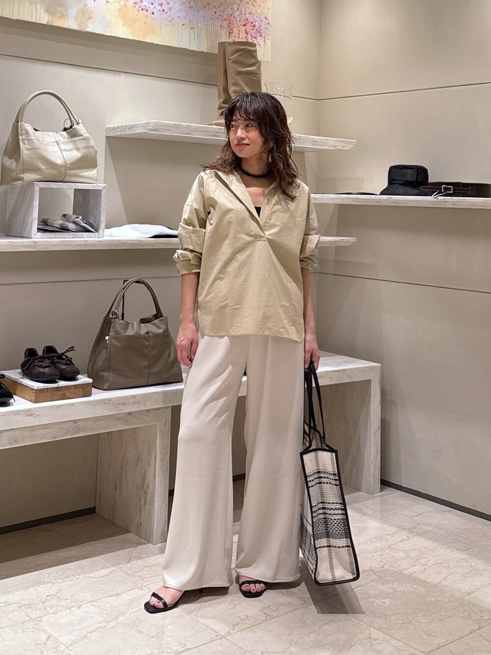 ベージュ系のシャツ/ブラウス、ベージュ系のその他パンツ、ブラック系のトートバッグを着用したレディースの春コーディネートの2枚目の写真