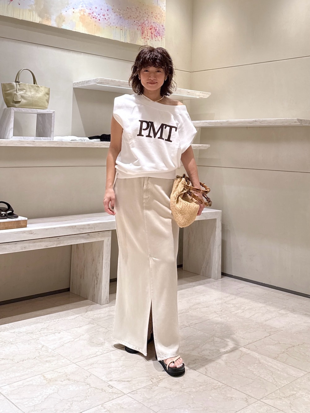 ホワイト系のスカート、ベージュ系のかごバッグ、ホワイト系のTシャツ/カットソーを着用したレディースの夏コーディネートの2枚目の写真