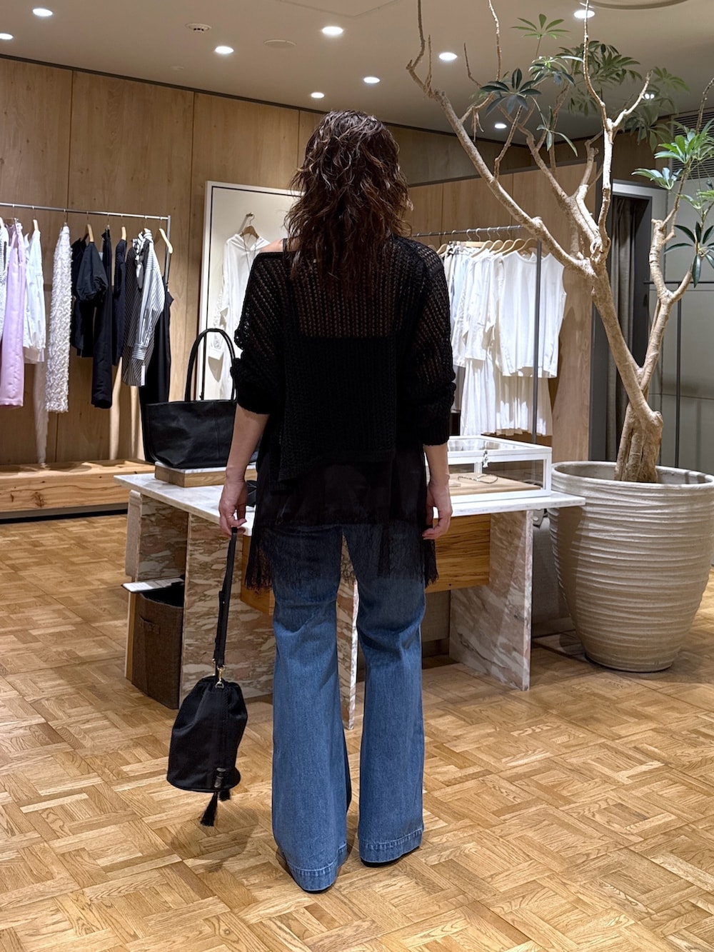 ブラック系のパーカー、ブラック系のシャツ/ブラウス、ブルー系のデニムパンツを着用したレディースの春コーディネートの3枚目の写真