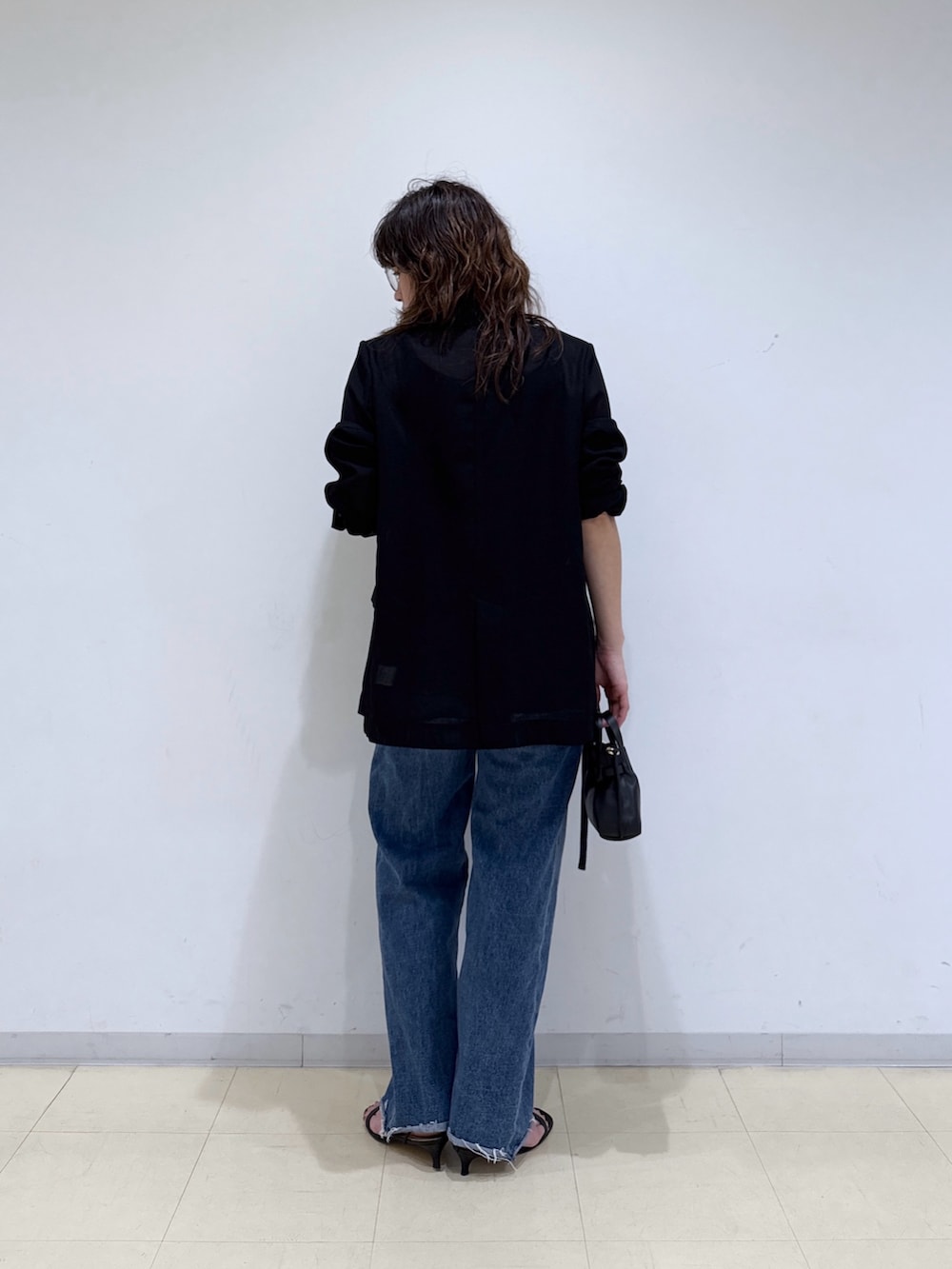 ブルー系のデニムスカート、ブルー系のデニムパンツ、ブラック系のニット/セーターを着用したレディースの春コーディネートの3枚目の写真
