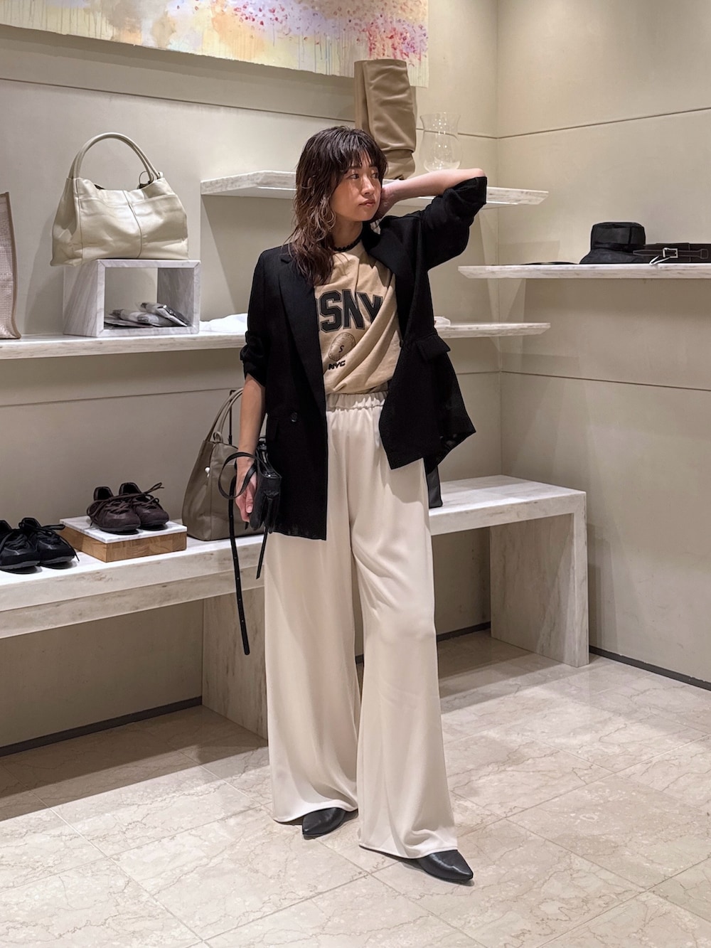 ブラック系のテーラードジャケット、ベージュ系のその他パンツ、ベージュ系のTシャツ/カットソーを着用したレディースの春コーディネートの2枚目の写真