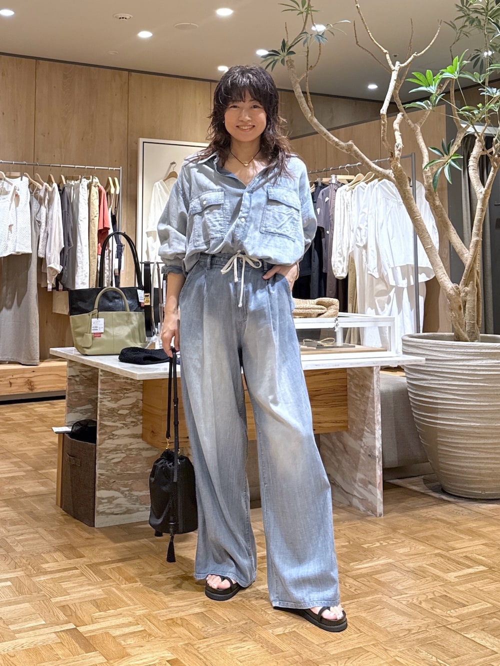 ブルー系のシャツ/ブラウス、ブルー系のその他パンツ、ブラック系のトートバッグを着用したレディースの夏コーディネートの4枚目の写真