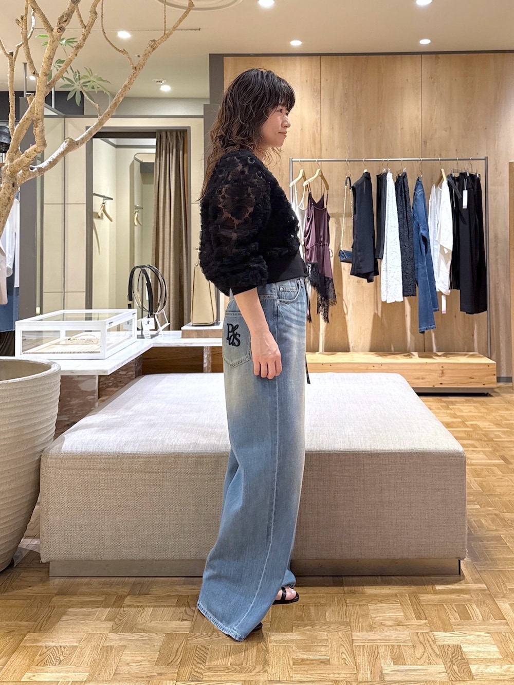 ブラック系のカーディガン/ボレロ、ブルー系のデニムパンツ、ブラック系のネックレスを着用したレディースの夏コーディネートの2枚目の写真