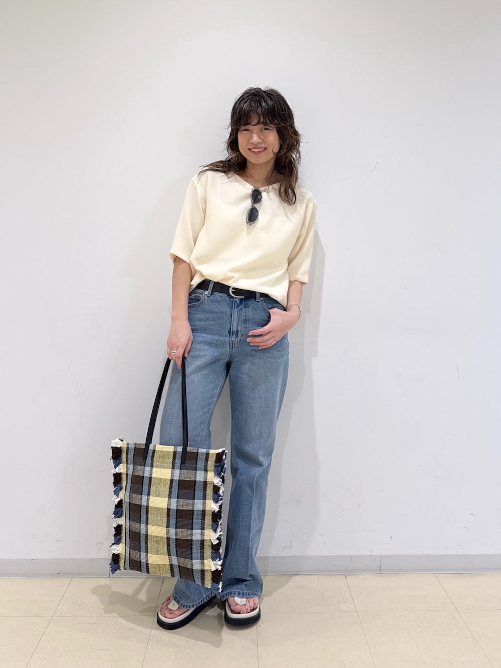 イエロー系のシャツ/ブラウス、ブルー系のデニムパンツ、イエロー系のトートバッグを着用したレディースの春コーディネートの5枚目の写真