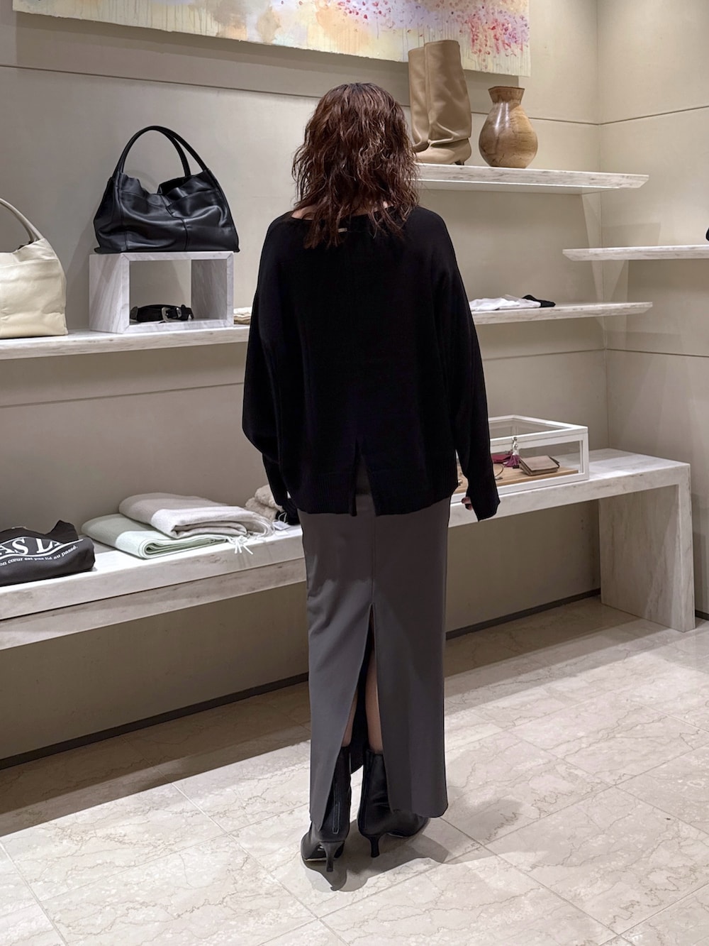 ブラック系のニット/セーター、グレー系のスカート、ブラック系のブーツを着用したレディースの冬コーディネートの3枚目の写真