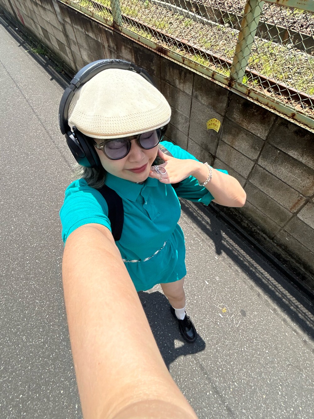 ホワイト系のTシャツ/カットソー、ブラック系のパンツ、ブラック系の帽子を着用したレディースの夏コーディネートの5枚目の写真