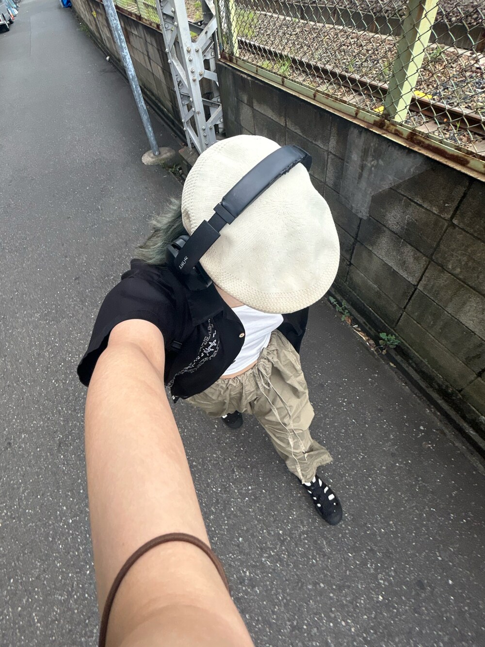 ホワイト系のTシャツ/カットソー、ブラック系のパンツ、ブラック系の帽子を着用したレディースの夏コーディネートの3枚目の写真