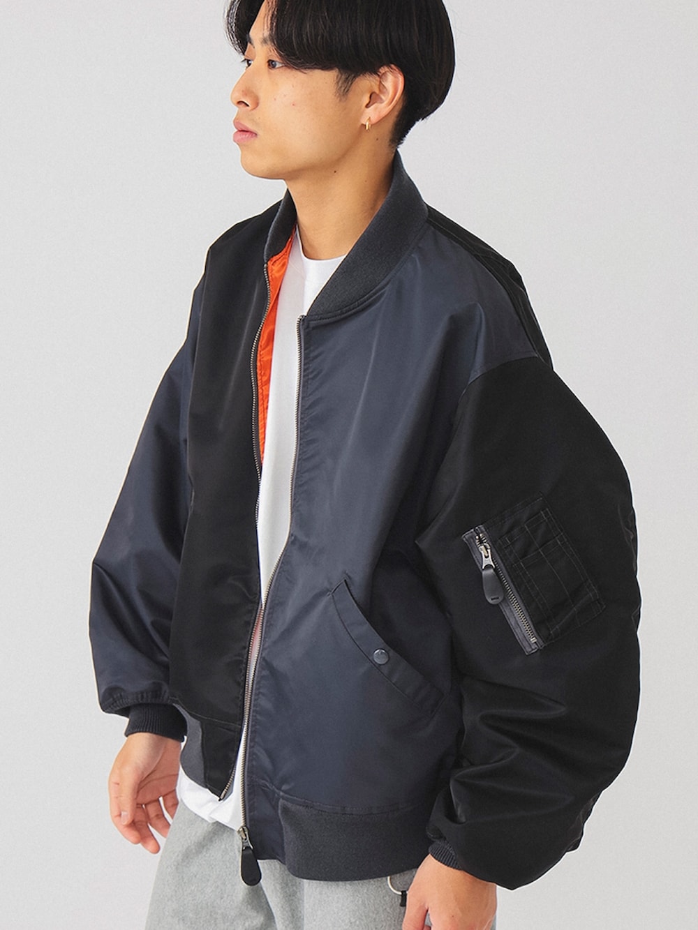 グレー系のスウェットパンツ、ブラック系のMA-1を着用したメンズの冬コーディネートの2枚目の写真