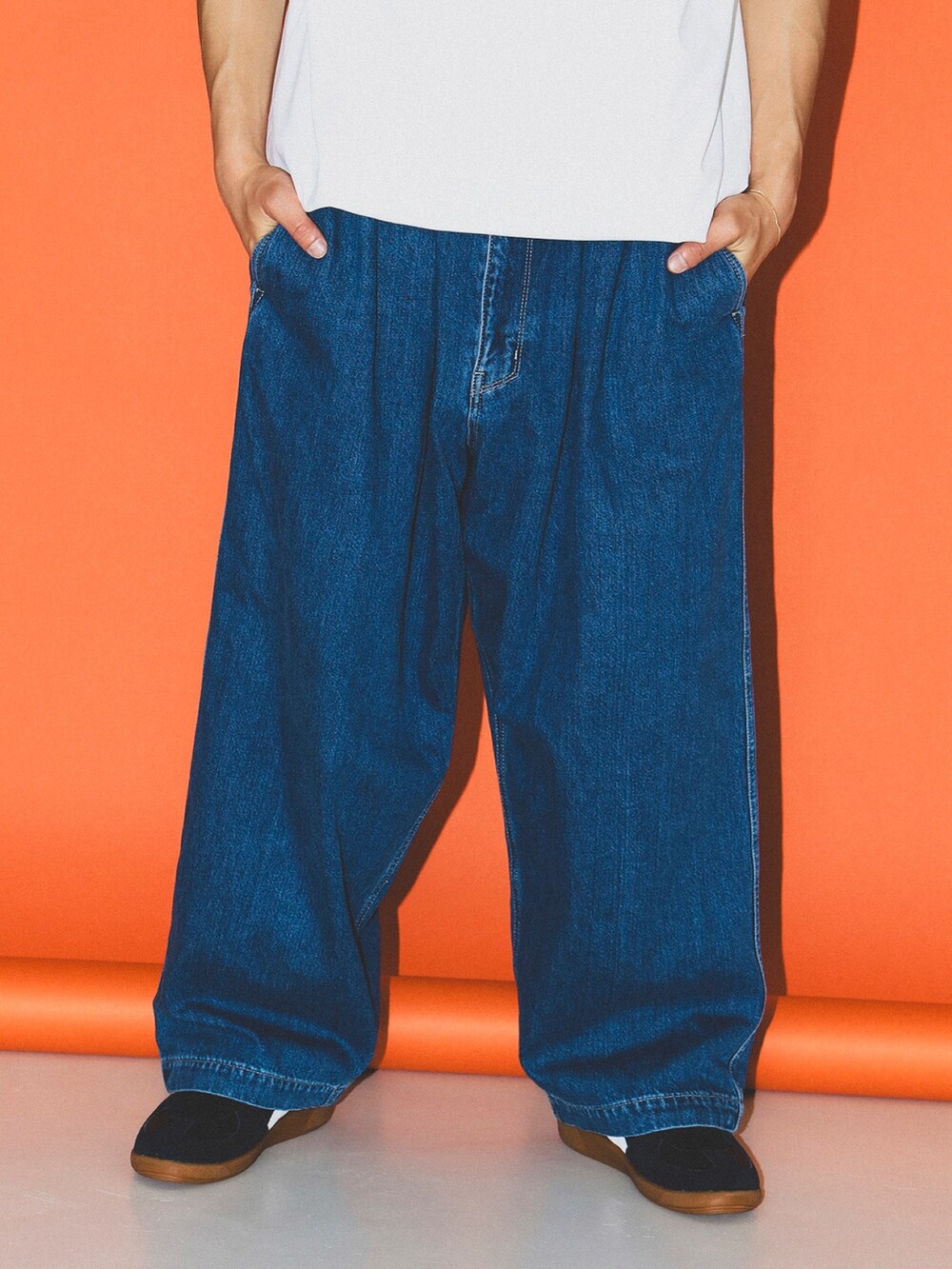 ホワイト系のTシャツ/カットソー、ブルー系のデニムパンツ、ブラック系のサングラスを着用したメンズの春コーディネートの3枚目の写真