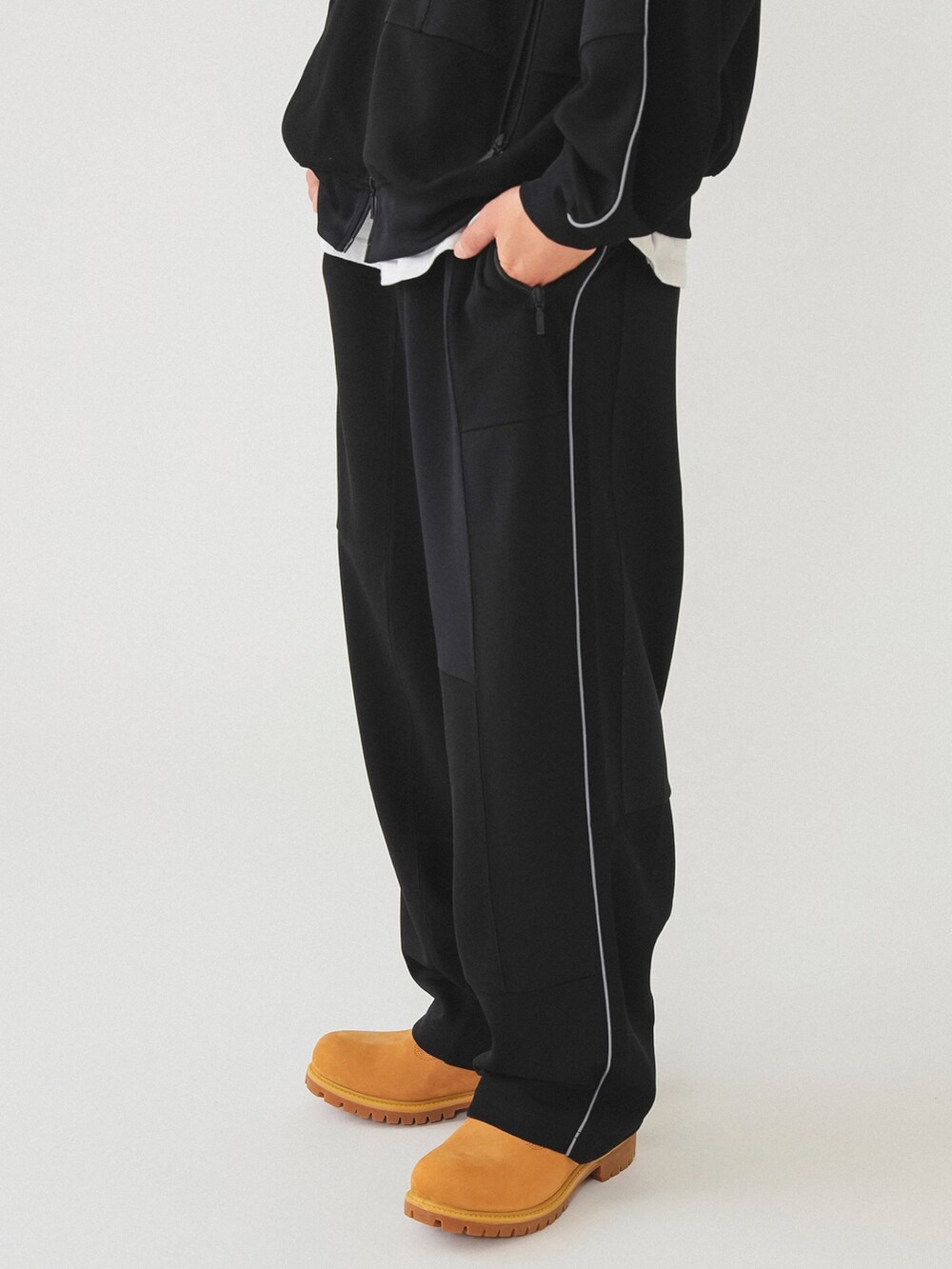 ブラック系のその他パンツ、ベージュ系のブーツ、ブラック系のジャージを着用したメンズの冬コーディネートの3枚目の写真