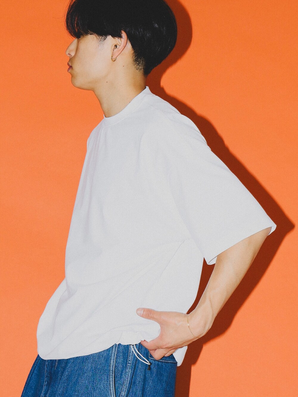 ホワイト系のTシャツ/カットソー、ブルー系のデニムパンツ、ブラック系のサングラスを着用したメンズの春コーディネートの2枚目の写真