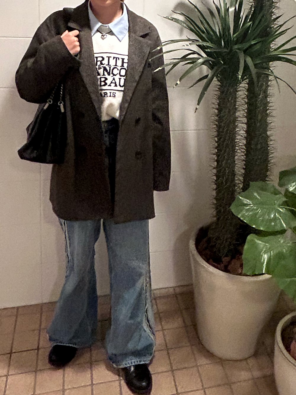 ブルー系のデニムパンツ、ブラック系のローファー、ブラウン系のテーラードジャケットを着用したレディースの秋コーディネートの2枚目の写真