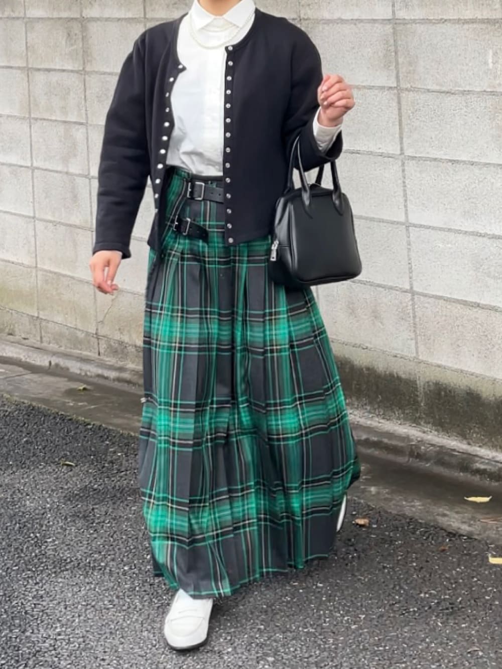 ブラック系のカーディガン/ボレロ、ブラック系のボストンバッグ、グリーン系のスカートを着用したレディースの秋コーディネートの2枚目の写真
