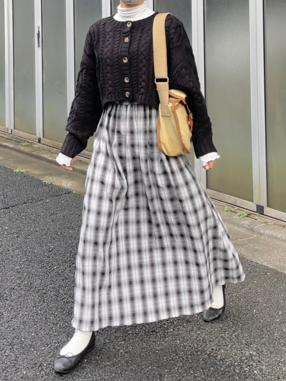 ブラック系のニット/セーター、ホワイト系のワンピース、ベージュ系のショルダーバッグを着用したレディースの秋コーディネートの2枚目の写真