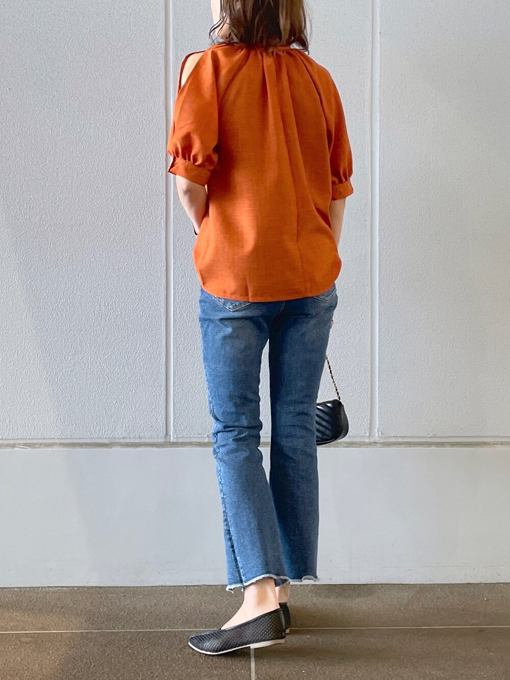 オレンジ系のシャツ/ブラウス、ブルー系のデニムパンツ、ブラック系のパンプスを着用したレディースの夏コーディネートの2枚目の写真