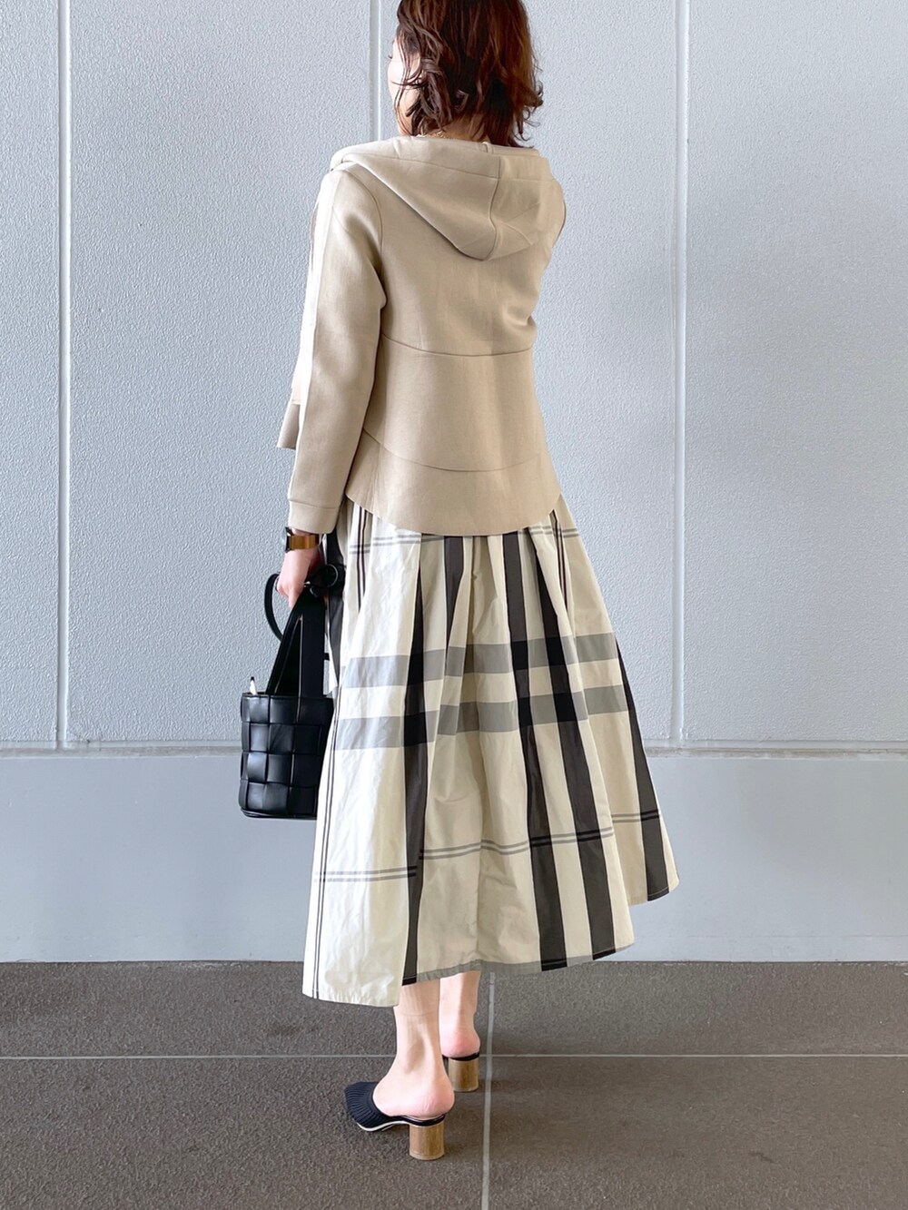 ホワイト系のTシャツ/カットソー、ブラック系のショルダーバッグ、ベージュ系のパンプスを着用したレディースの春コーディネートの2枚目の写真