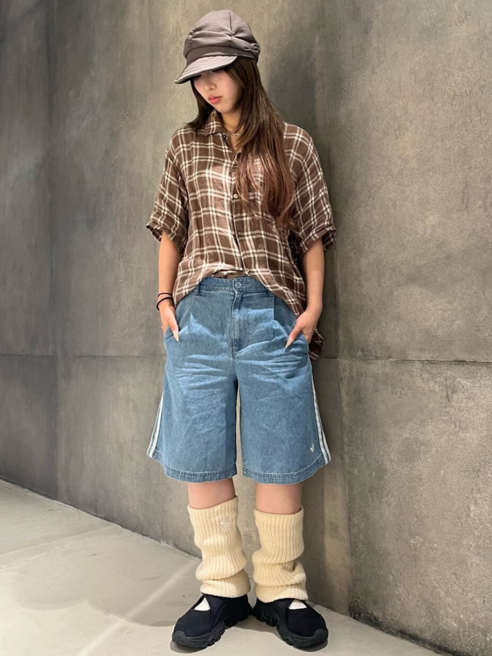 ブルー系のデニムパンツ、ブラック系のスニーカー、ホワイト系のレッグウォーマーを着用したレディースの夏コーディネートの2枚目の写真