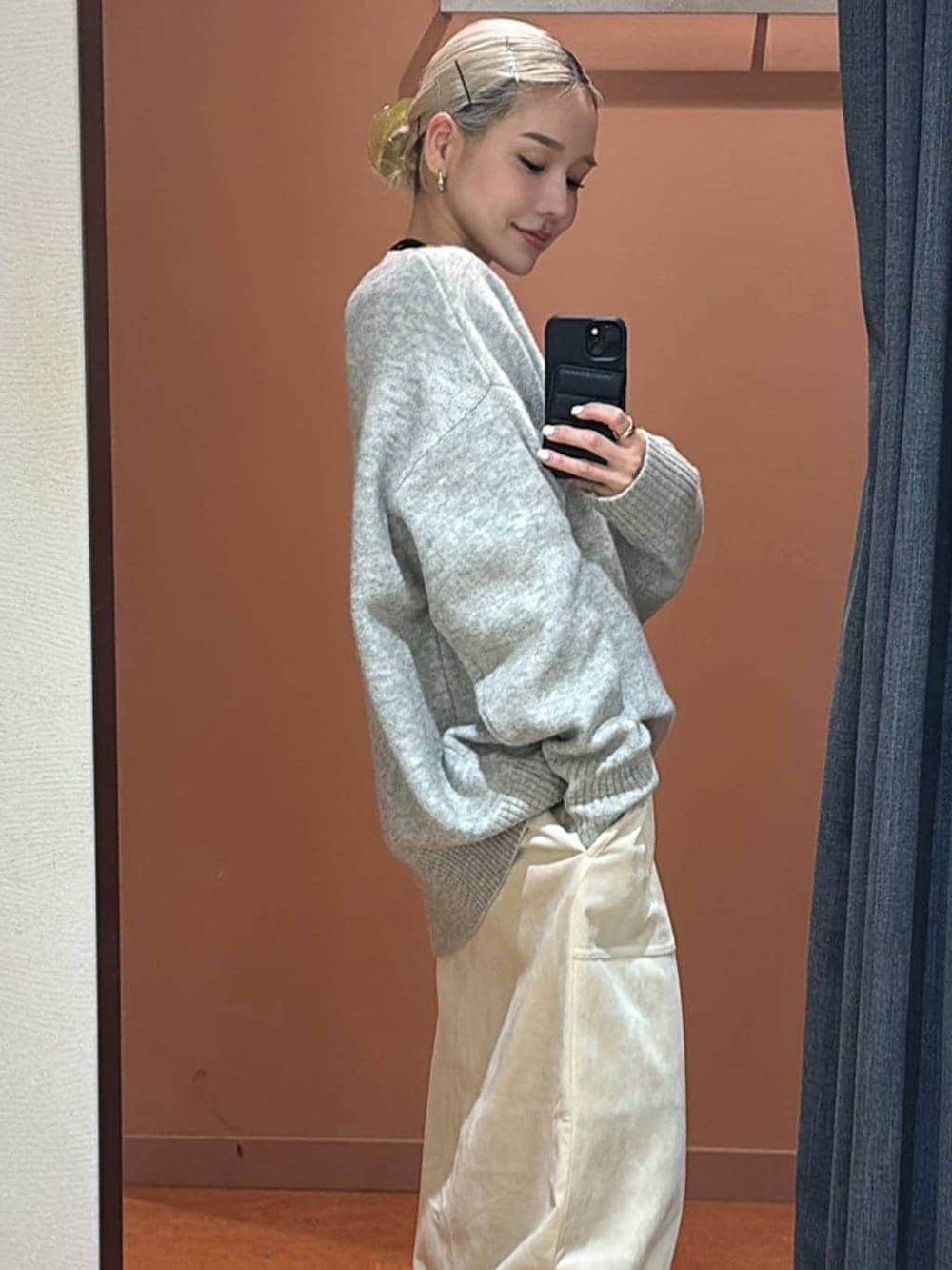 ホワイト系のスカート、ブラック系のブーツ、グレー系のニット/セーターを着用したレディースの冬コーディネートの4枚目の写真