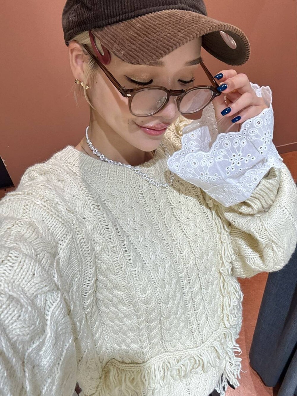 ブラウン系のスカート、ホワイト系のTシャツ/カットソー、ブルー系のニット/セーターを着用したレディースの秋コーディネートの2枚目の写真