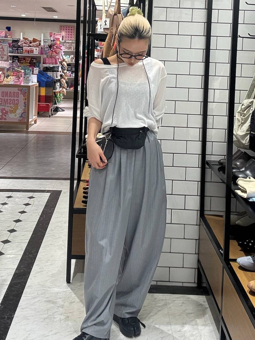 グレー系のその他パンツ、ホワイト系のTシャツ/カットソー、ブラック系のボディバッグ/ウエストポーチを着用したレディースの春コーディネートの2枚目の写真