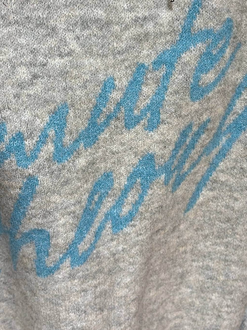 ホワイト系のスカート、ブラック系のブーツ、グレー系のニット/セーターを着用したレディースの冬コーディネートの8枚目の写真