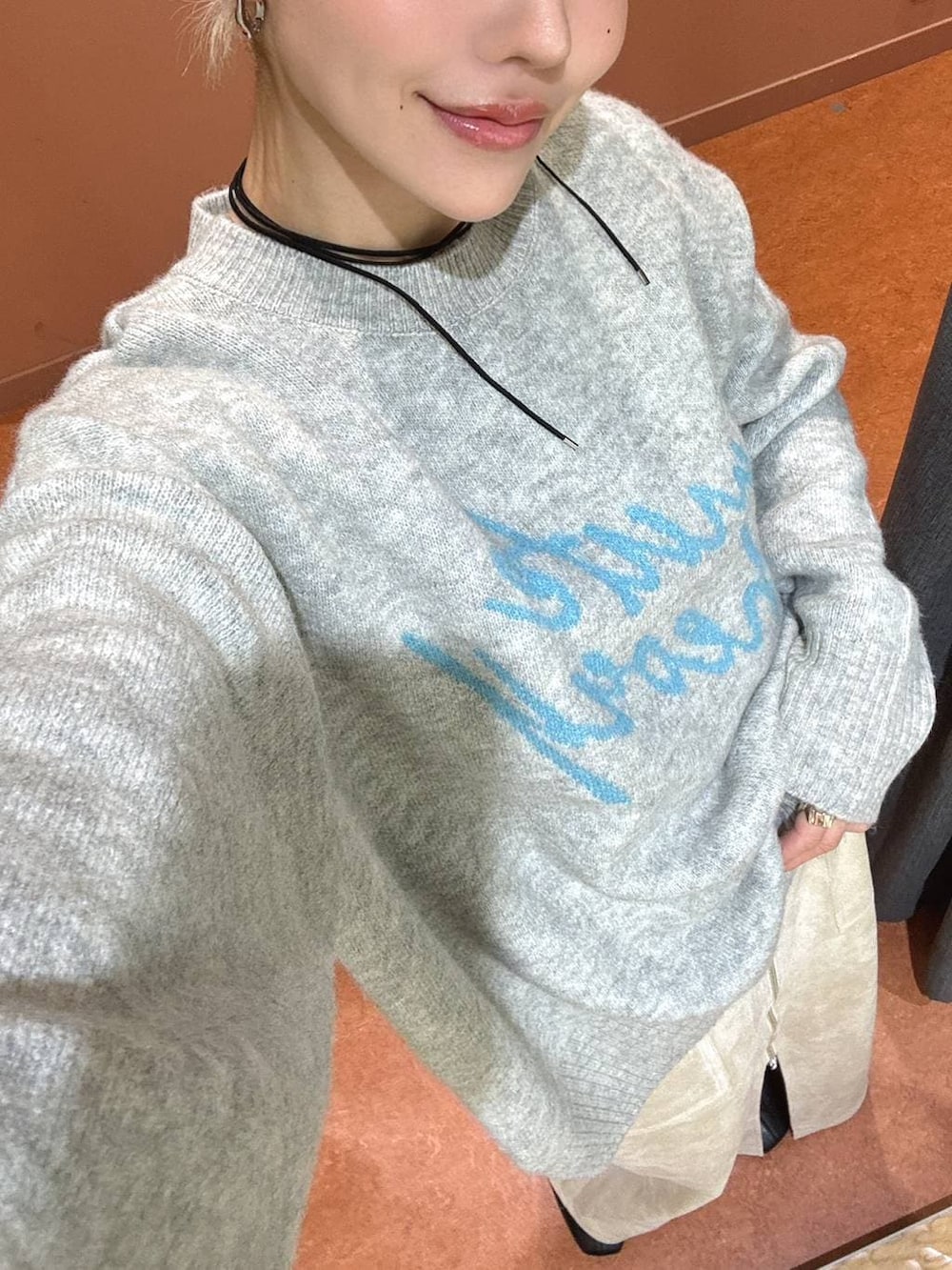 ホワイト系のスカート、ブラック系のブーツ、グレー系のニット/セーターを着用したレディースの冬コーディネートの5枚目の写真