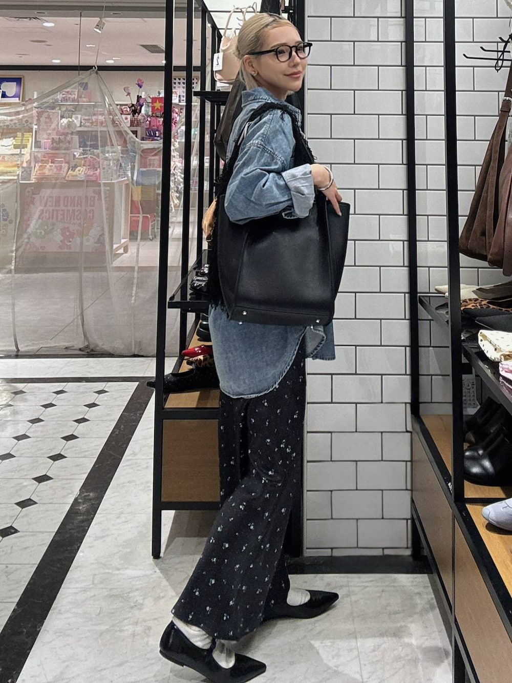 ブラック系のスカート、ブラック系のパンプス、ブルー系のシャツ/ブラウスを着用したレディースの春コーディネートの3枚目の写真