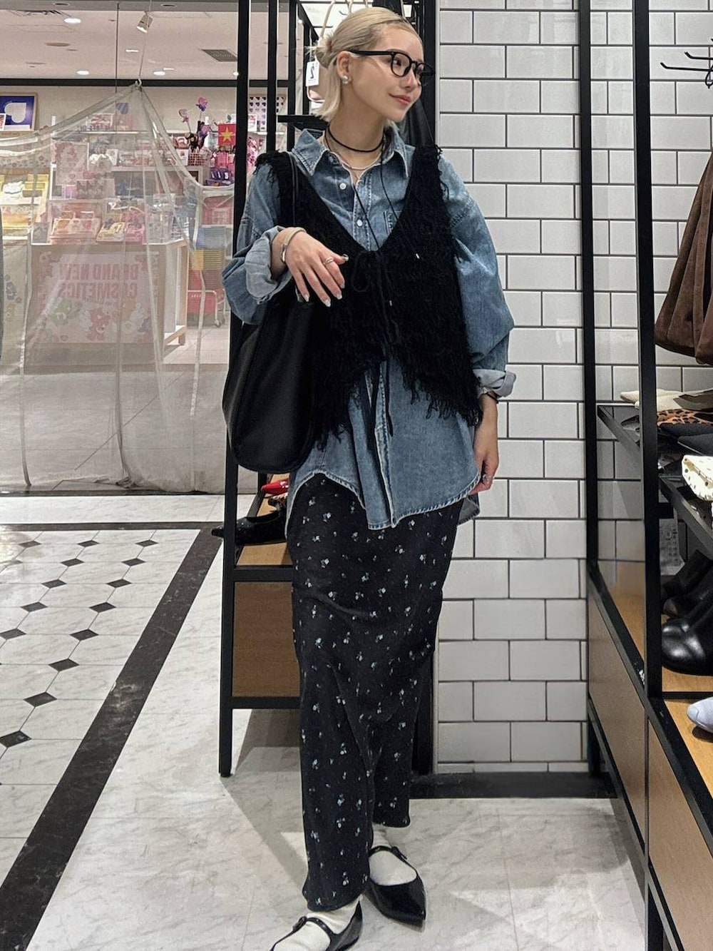 ブラック系のスカート、ブラック系のパンプス、ブルー系のシャツ/ブラウスを着用したレディースの春コーディネートの4枚目の写真