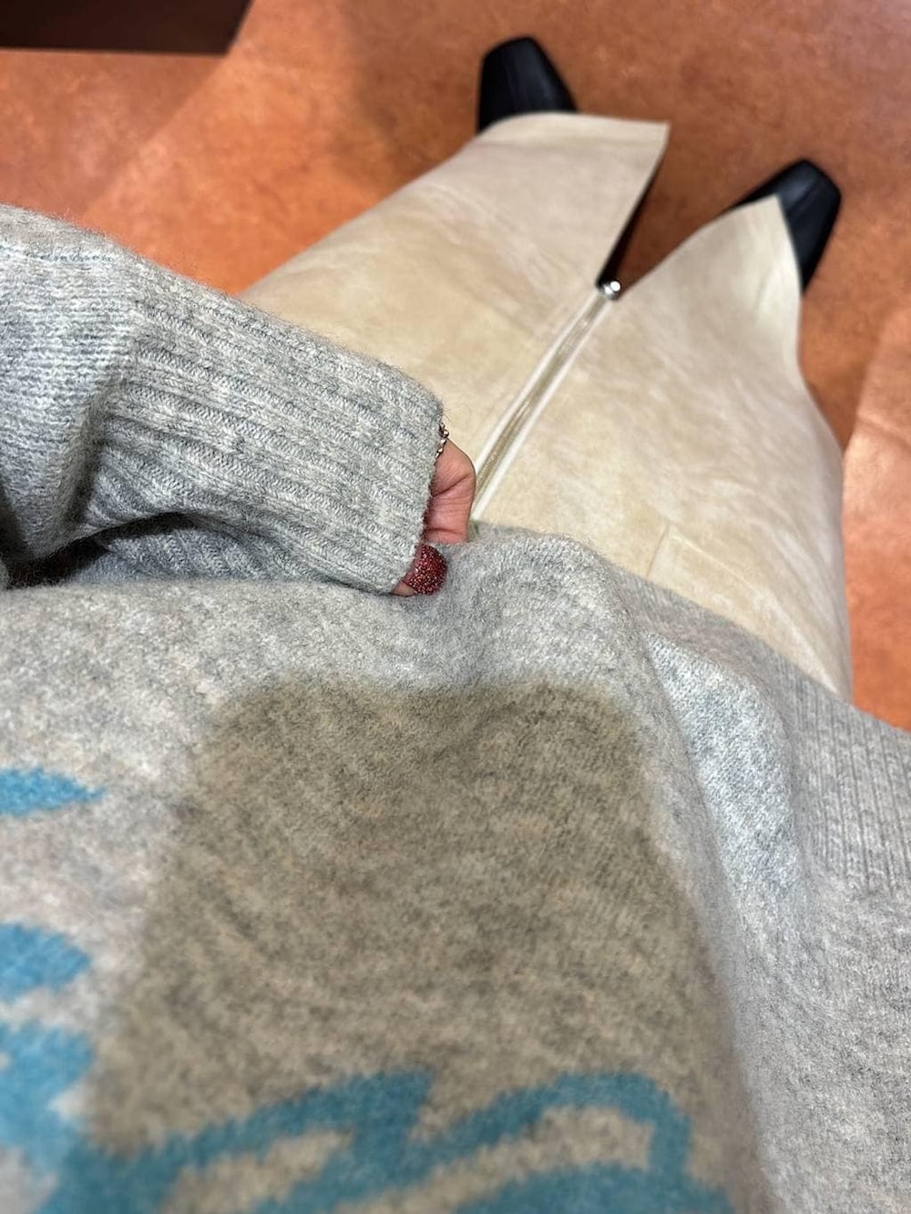 ホワイト系のスカート、ブラック系のブーツ、グレー系のニット/セーターを着用したレディースの冬コーディネートの6枚目の写真