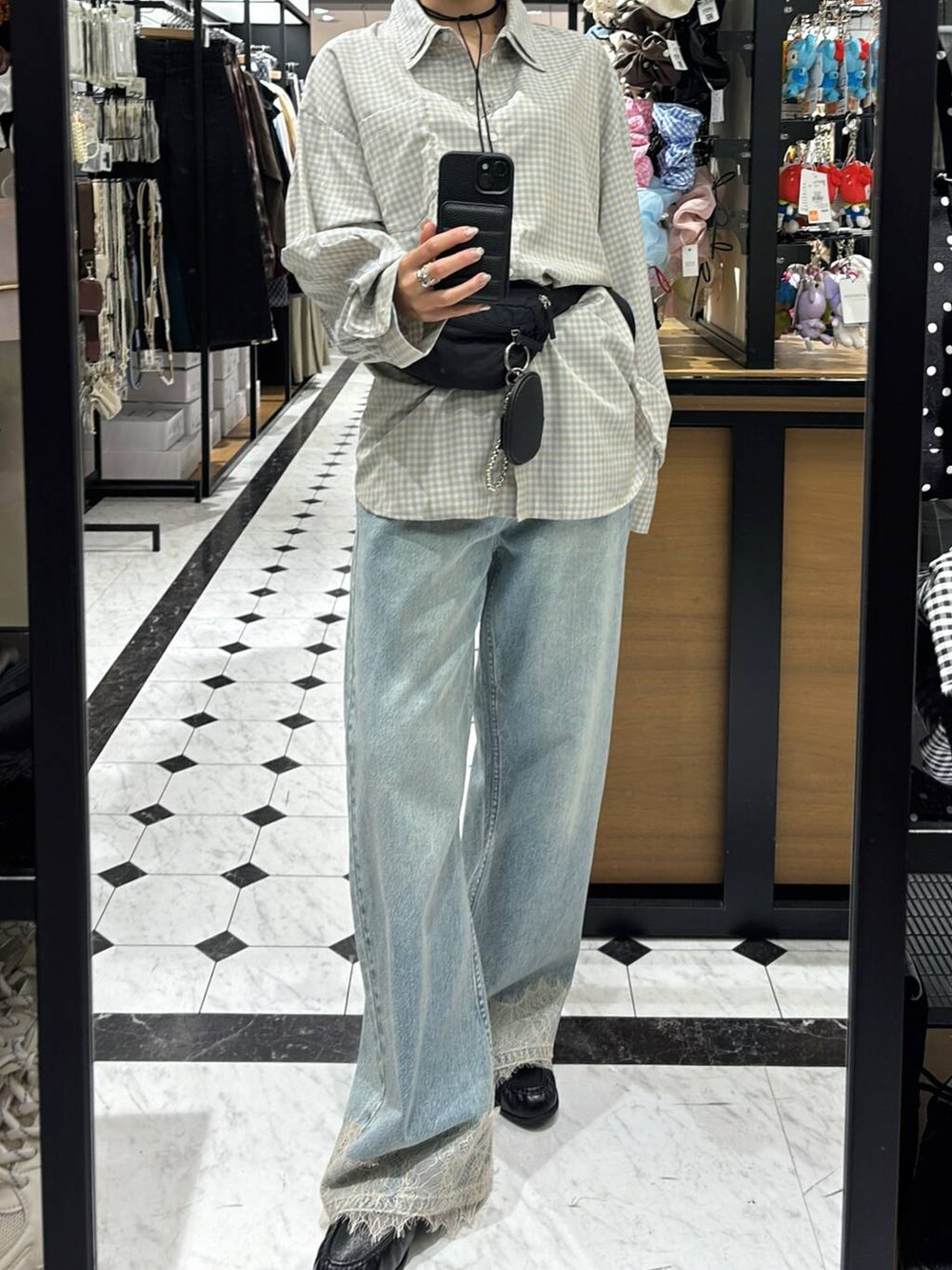 ブルー系のデニムパンツ、ブラック系のボディバッグ/ウエストポーチ、ブラック系のローファーを着用したレディースの春コーディネートの6枚目の写真