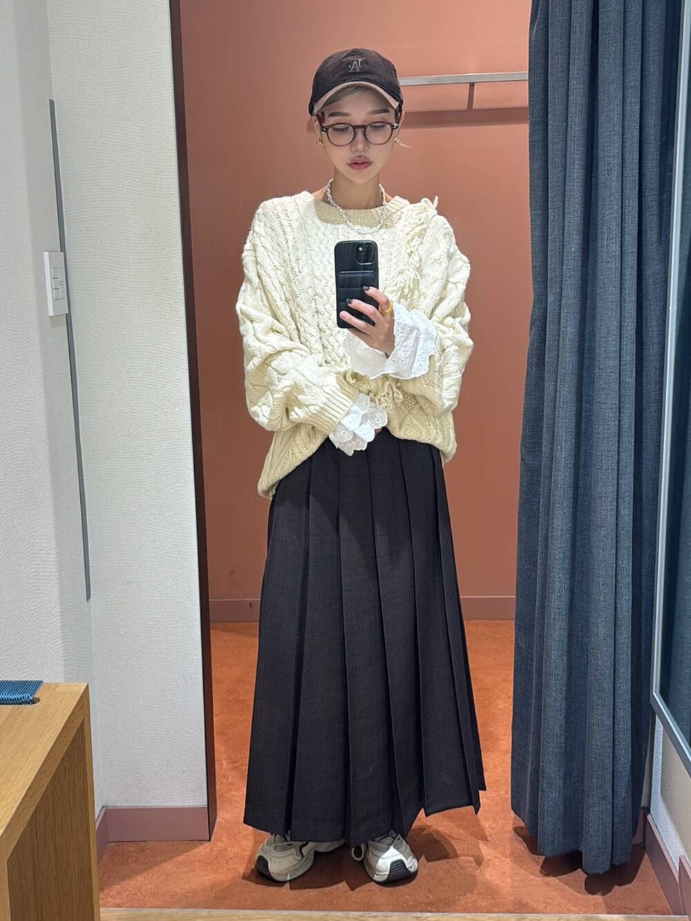 ブラウン系のスカート、ホワイト系のTシャツ/カットソー、ブルー系のニット/セーターを着用したレディースの秋コーディネートの3枚目の写真