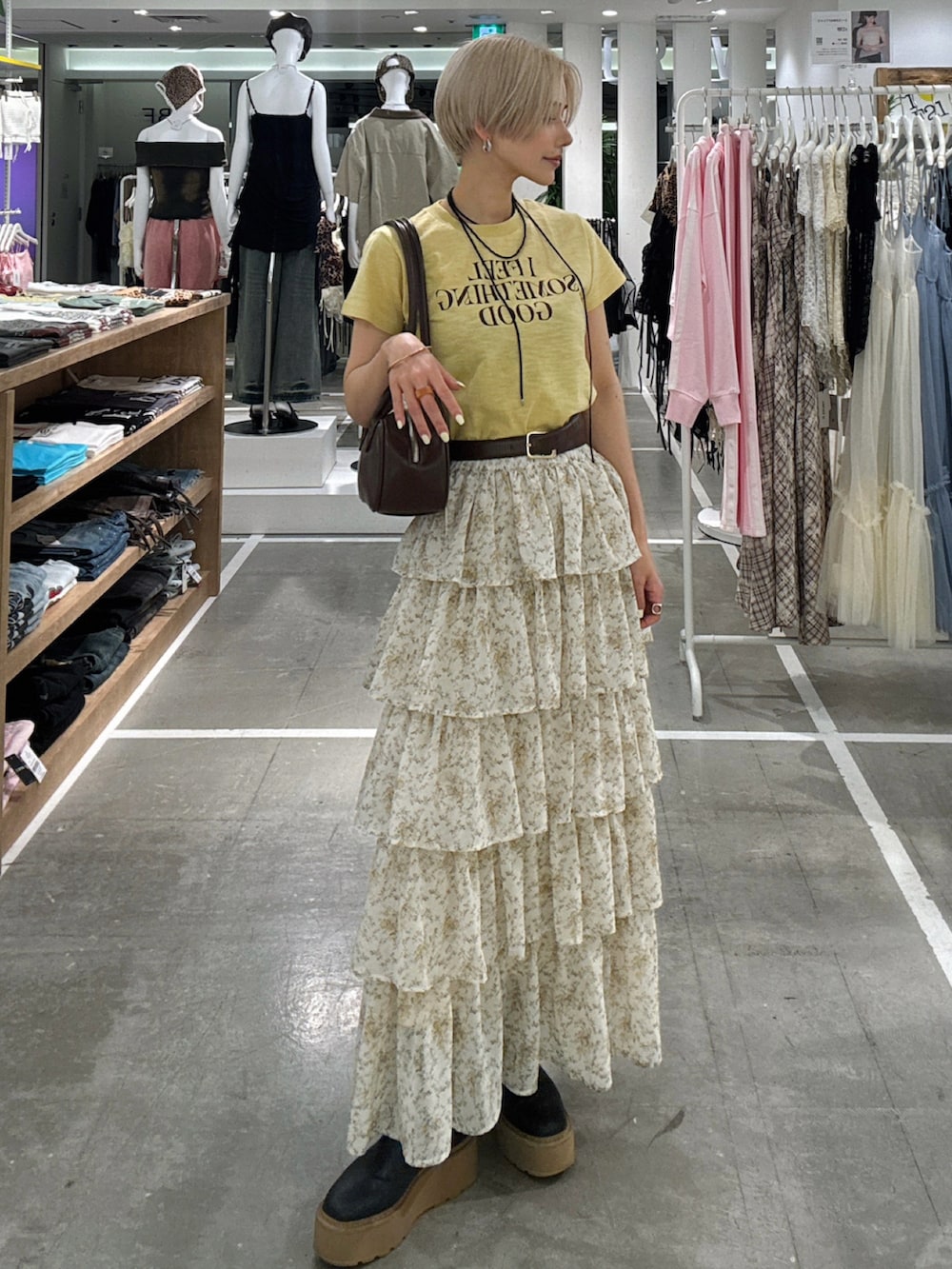 イエロー系のTシャツ/カットソー、ベージュ系のスカートを着用したレディースの春コーディネートの2枚目の写真