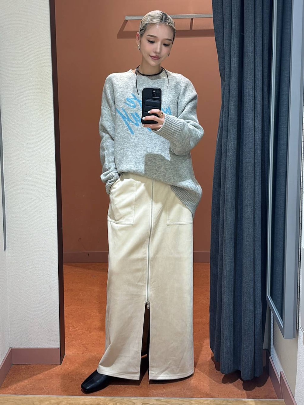 ホワイト系のスカート、ブラック系のブーツ、グレー系のニット/セーターを着用したレディースの冬コーディネートの2枚目の写真