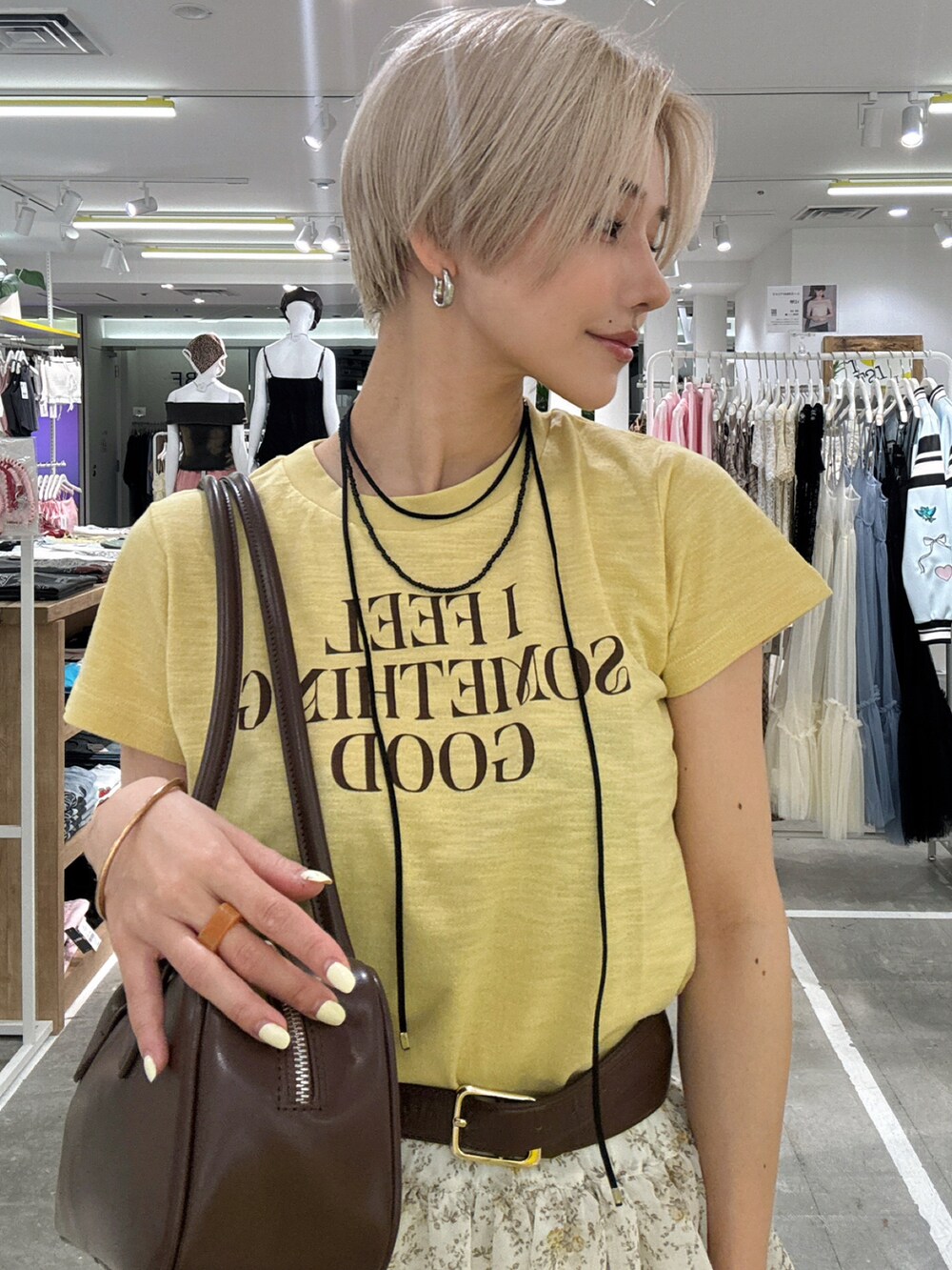 イエロー系のTシャツ/カットソー、ベージュ系のスカートを着用したレディースの春コーディネートの4枚目の写真