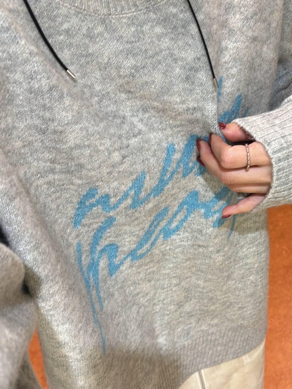 ホワイト系のスカート、ブラック系のブーツ、グレー系のニット/セーターを着用したレディースの冬コーディネートの7枚目の写真