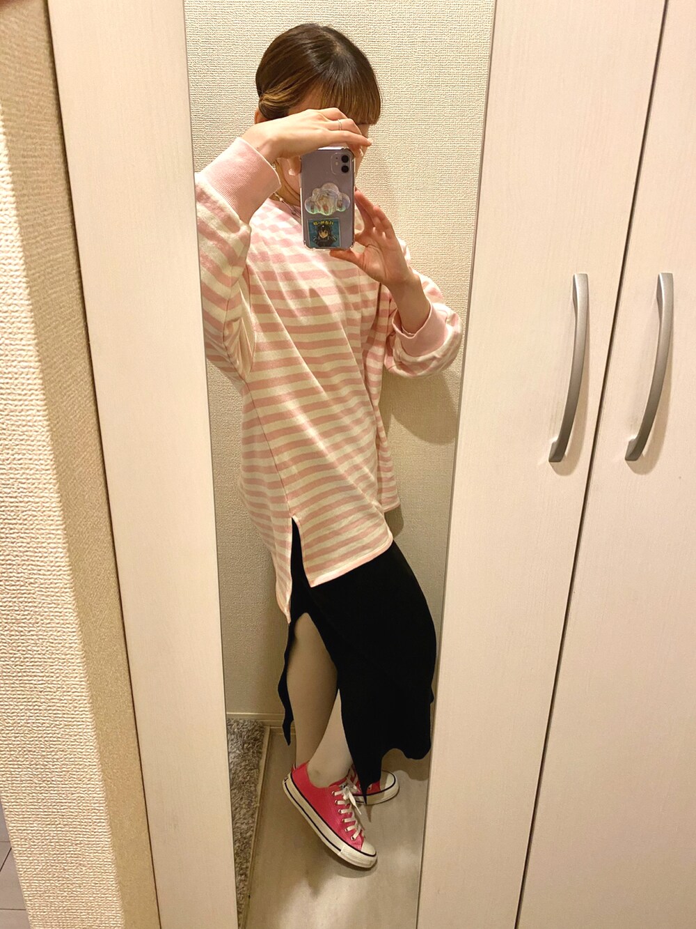 ピンク系のスウェット、ブラック系のスカート、ピンク系のスニーカーを着用したレディースの春コーディネートの2枚目の写真