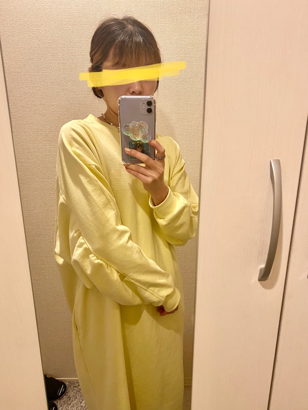 イエロー系のワンピース、ブラック系のパンプスを着用したレディースの春コーディネートの2枚目の写真