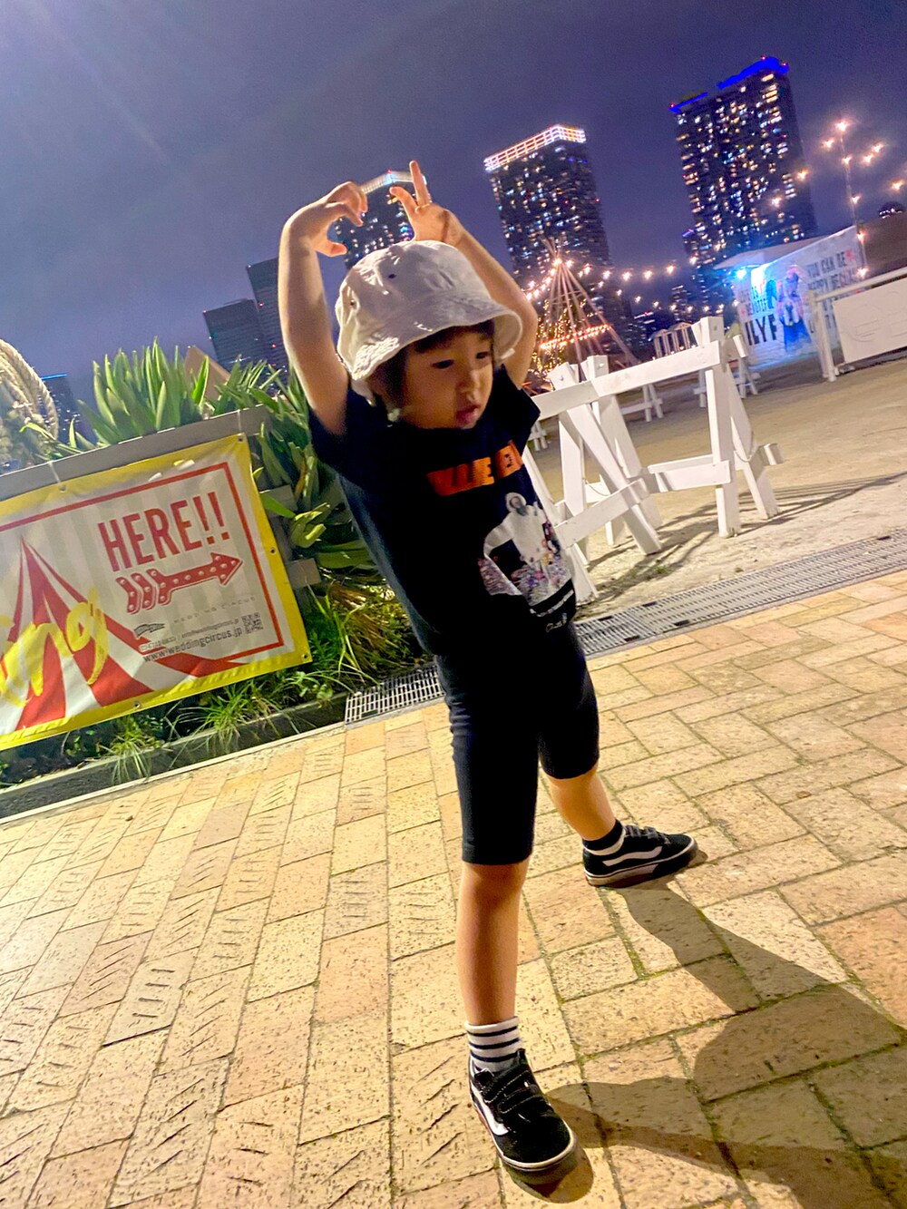 ブラック系のTシャツ/カットソー、ブラック系のスニーカー、ホワイト系のハットを着用したキッズの冬コーディネートの2枚目の写真