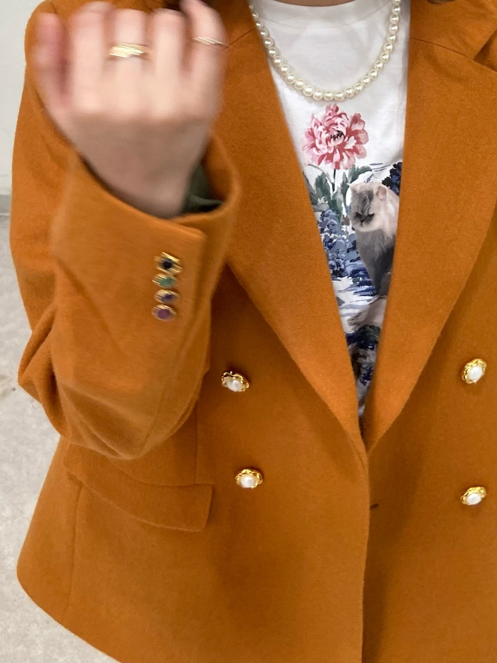 オレンジ系のジャケット/アウター、ホワイト系のTシャツ/カットソー、ブラウン系のブーツを着用したレディースの春コーディネートの2枚目の写真