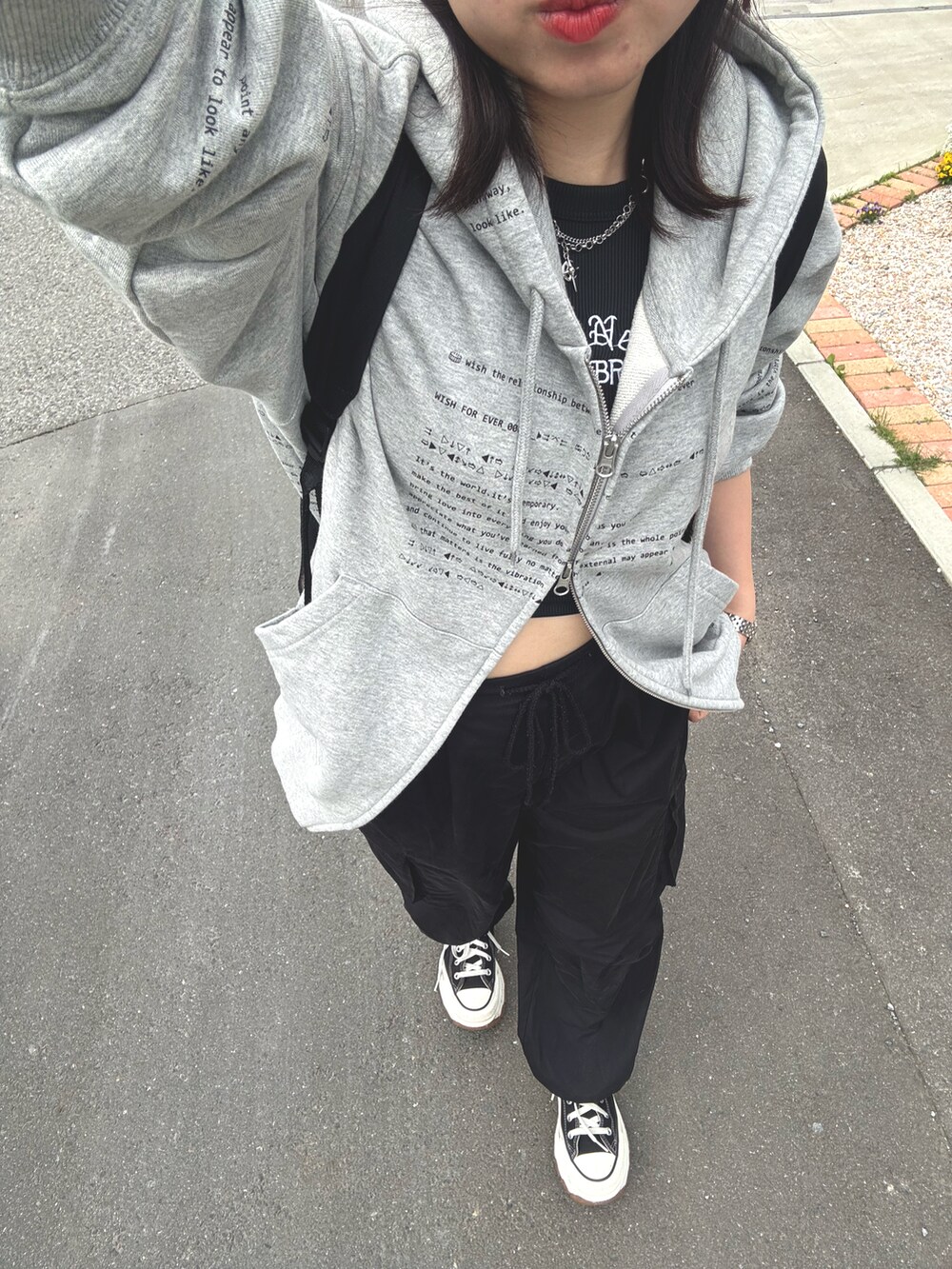 ブラック系のタンクトップ、ブラック系のカーゴパンツ、ブラック系のスニーカーを着用したレディースの春コーディネートの2枚目の写真