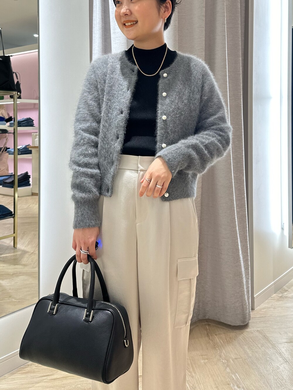 ベージュ系のカーゴパンツ、ブラック系のニット/セーター、グレー系のカーディガン/ボレロを着用したレディースの秋コーディネートの3枚目の写真