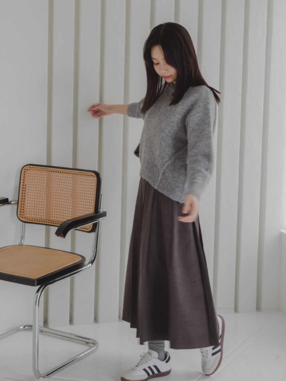 ホワイト系のTシャツ/カットソー、グレー系のスカート、グレー系のニット/セーターを着用したレディースの秋コーディネートの3枚目の写真